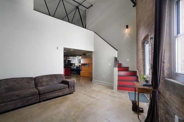 3059 N Weil St Unit 124, Milwaukee, WI 53212 - living area with a towering ceiling, light tile patterned floors, stairway, and baseboards