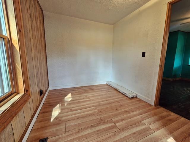 5183 2nd Ave, Pittsville, WI 54466 - empty room with light wood-style floors, a textured ceiling, baseboards, and a textured wall