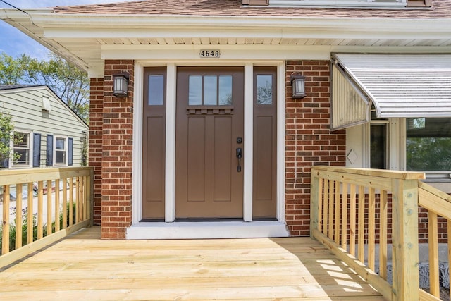 4648 S Kansas Ave Unit 4650, Saint Francis, WI 53235 - view of exterior entry featuring brick siding, roof with shingles, and a wooden deck