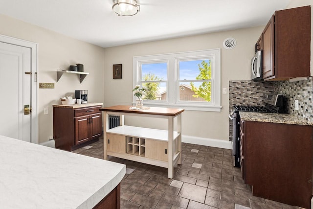 4648 S Kansas Ave Unit 4650, Saint Francis, WI 53235 - kitchen featuring appliances with stainless steel finishes, light countertops, open shelves, baseboards, and backsplash