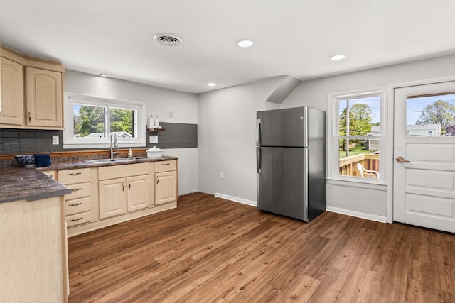4648 S Kansas Ave Unit 4650, Saint Francis, WI 53235 - kitchen with freestanding refrigerator, a sink, dark countertops, tasteful backsplash, and wood finished floors