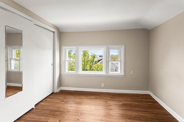 4648 S Kansas Ave Unit 4650, Saint Francis, WI 53235 - unfurnished bedroom with multiple windows, a closet, wood finished floors, and baseboards