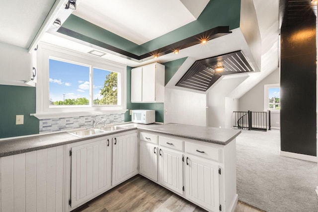 1925 Salisbury Rd, West Bend, WI 53090 - kitchen with a sink, white microwave, a peninsula, white cabinets, and light carpet