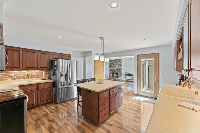 N101W16063 Santa Fe Dr, Germantown, WI 53022 - kitchen featuring stainless steel refrigerator with ice dispenser, range with electric cooktop, a sink, light wood-style flooring, and light countertops
