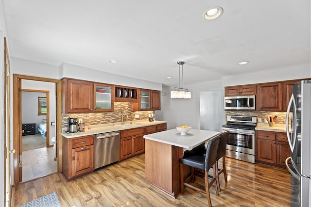 N101W16063 Santa Fe Dr, Germantown, WI 53022 - kitchen with stainless steel appliances, backsplash, a kitchen island, light countertops, and recessed lighting