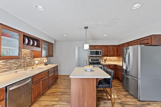 N101W16063 Santa Fe Dr, Germantown, WI 53022 - kitchen with stainless steel appliances, a sink, tasteful backsplash, a kitchen bar, and glass insert cabinets