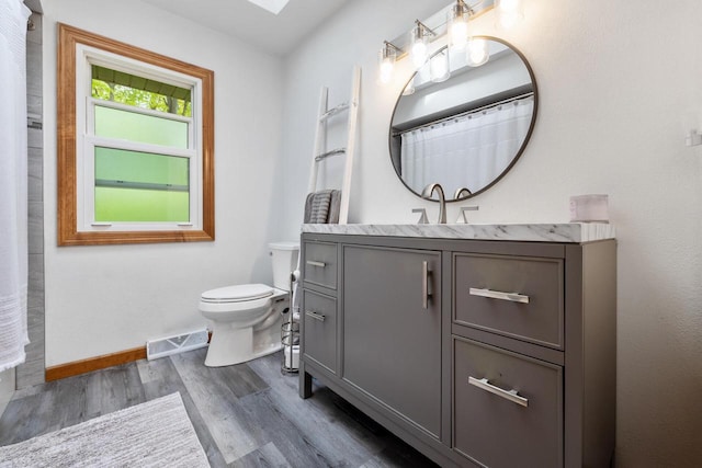 3324 County Highway Cc, Slinger, WI 53086 - bathroom featuring wood finished floors, toilet, vanity, and baseboards