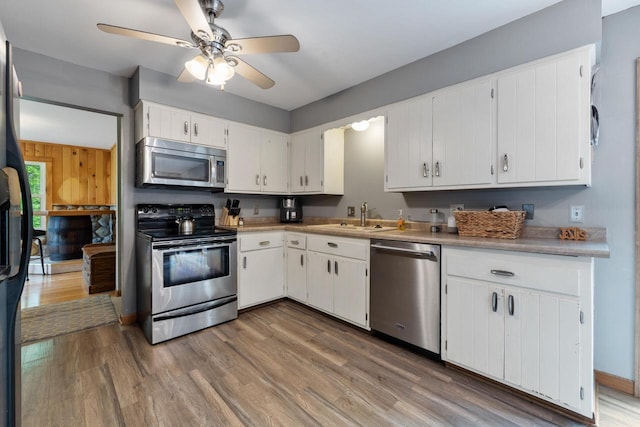 3324 County Highway Cc, Slinger, WI 53086 - kitchen featuring appliances with stainless steel finishes, a sink, wood finished floors, and white cabinets