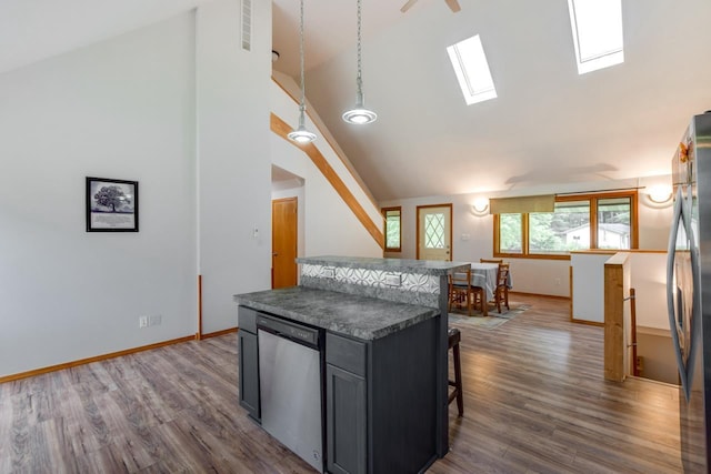 E3581 Green Valley Dr, La Valle, WI 53941 - kitchen featuring appliances with stainless steel finishes, a kitchen breakfast bar, dark wood finished floors, a kitchen island, and a skylight