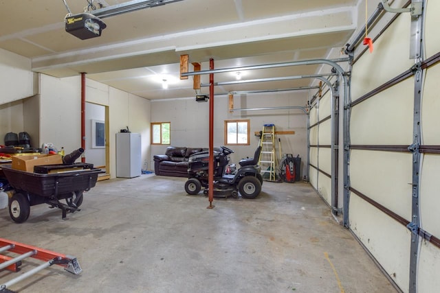 E3581 Green Valley Dr, La Valle, WI 53941 - garage featuring a garage door opener, electric panel, and fridge