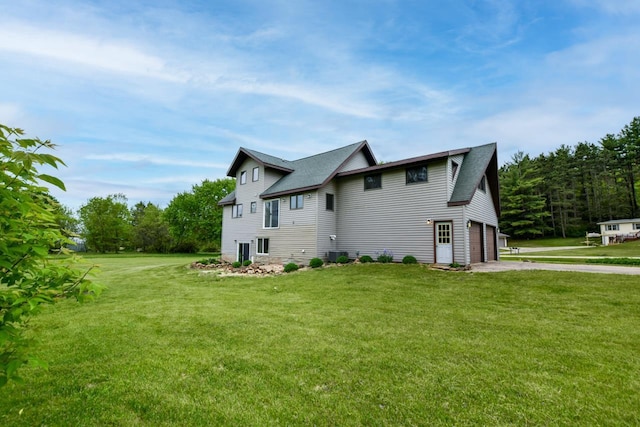 E3581 Green Valley Dr, La Valle, WI 53941 - view of side of property featuring driveway, a lawn, and an attached garage