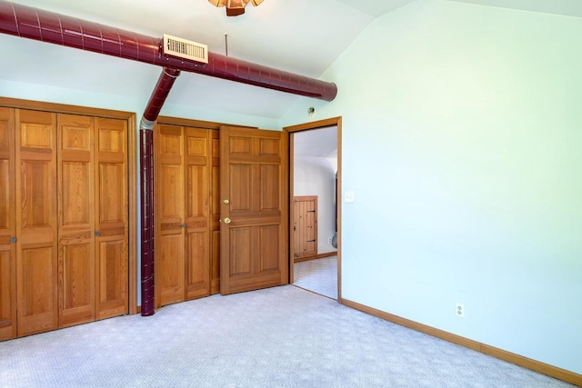 N9056 16th Ave, Neshkoro, WI 54960 - unfurnished bedroom featuring vaulted ceiling, light carpet, baseboards, and two closets