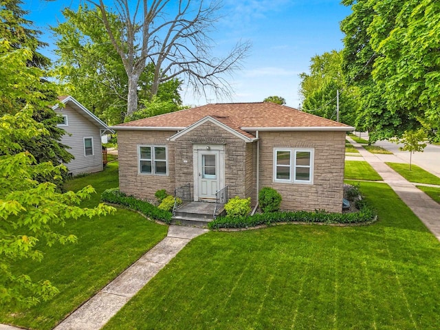203 E 1st St, Kimberly, WI 54136 - bungalow featuring stone siding, a front lawn, and roof with shingles