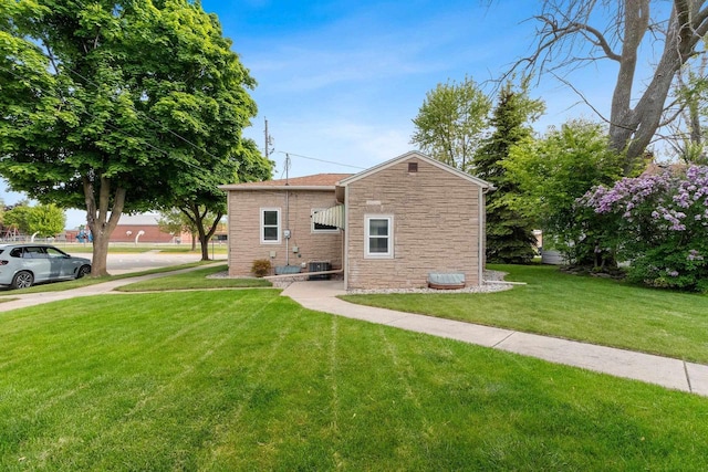 203 E 1st St, Kimberly, WI 54136 - view of side of home featuring stone siding, a yard, and central AC unit