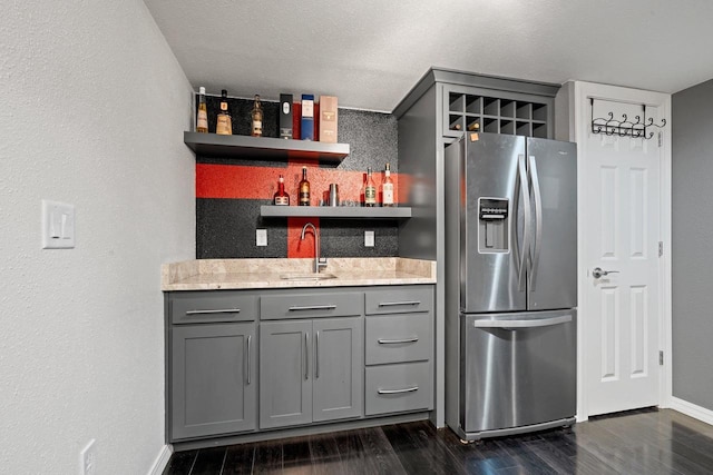 410 E Washington St, New London, WI 54961 - kitchen featuring stainless steel fridge, gray cabinetry, a sink, and a textured wall