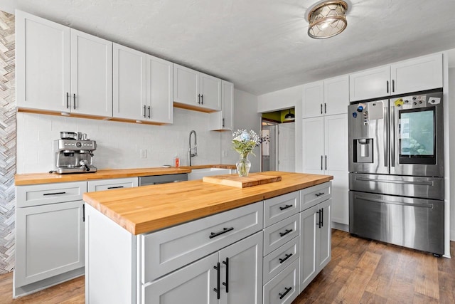 410 E Washington St, New London, WI 54961 - kitchen with butcher block countertops, stainless steel appliances, a sink, dark wood-type flooring, and tasteful backsplash
