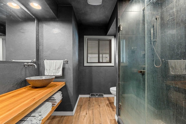 410 E Washington St, New London, WI 54961 - full bathroom with wood finished floors, a shower stall, toilet, and vanity