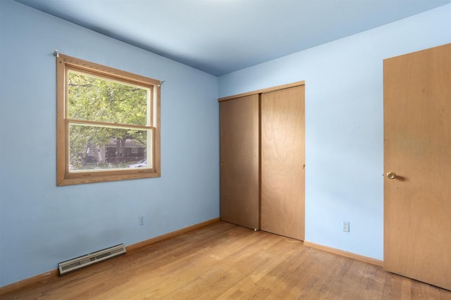 1054 Oxford Ct, Neenah, WI 54956 - unfurnished bedroom featuring wood finished floors, a closet, and baseboards