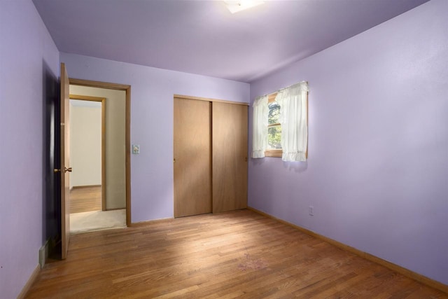 1054 Oxford Ct, Neenah, WI 54956 - unfurnished bedroom with wood finished floors, a closet, and baseboards