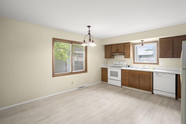 1054 Oxford Ct, Neenah, WI 54956 - kitchen featuring white appliances, light countertops, a sink, light wood-style flooring, and baseboards