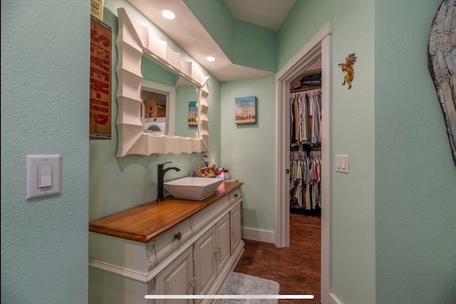 76 Hillside Rd, Edgerton, WI 53534 - bathroom featuring vanity, wood finished floors, washer / clothes dryer, a spacious closet, and recessed lighting
