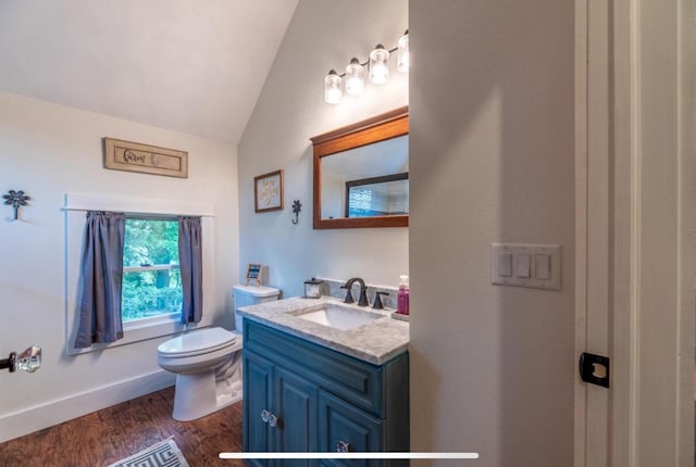 76 Hillside Rd, Edgerton, WI 53534 - bathroom featuring lofted ceiling, toilet, vanity, wood finished floors, and baseboards