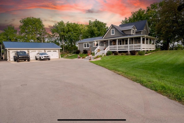 76 Hillside Rd, Edgerton, WI 53534 - farmhouse-style home with a porch, a detached garage, a lawn, an outdoor structure, and metal roof