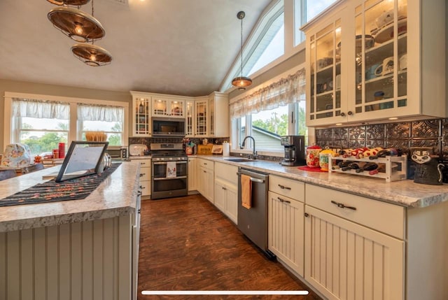 76 Hillside Rd, Edgerton, WI 53534 - kitchen featuring stainless steel appliances, a sink, backsplash, vaulted ceiling, and decorative light fixtures