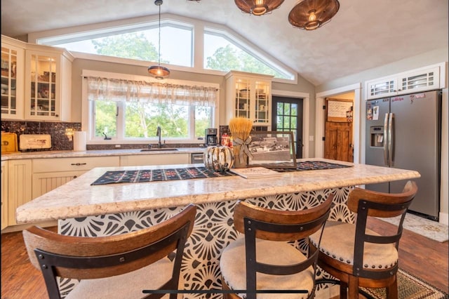 76 Hillside Rd, Edgerton, WI 53534 - kitchen with stainless steel refrigerator with ice dispenser, a sink, lofted ceiling, a breakfast bar, and black stovetop