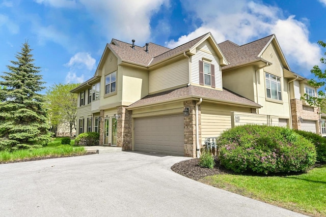 8687 S Deerwood Ln, Franklin, WI 53132 - townhome / multi-family property with a shingled roof, asphalt driveway, an attached garage, and stucco siding