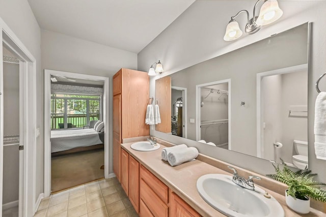 8687 S Deerwood Ln, Franklin, WI 53132 - bathroom with connected bathroom, double vanity, a spacious closet, toilet, and tile patterned flooring