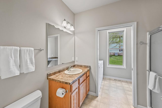 8687 S Deerwood Ln, Franklin, WI 53132 - full bath featuring vanity, toilet, separate washer and dryer, a shower with shower door, and baseboards