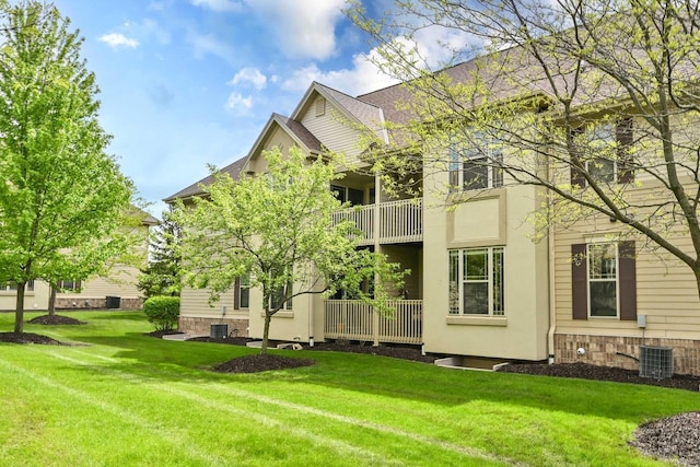 8687 S Deerwood Ln, Franklin, WI 53132 - back of property with a yard, cooling unit, a balcony, and stone siding