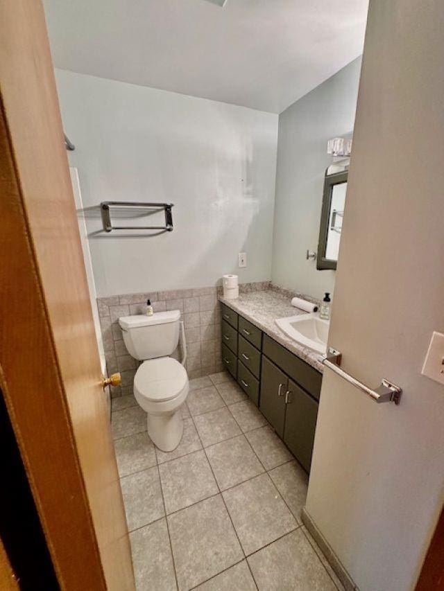 166 Gwynn St, Green Bay, WI 54301 - bathroom featuring tile patterned floors, vanity, toilet, a wainscoted wall, and tile walls