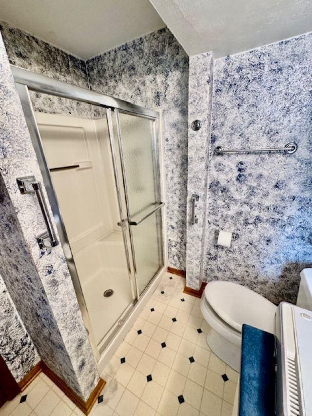 166 Gwynn St, Green Bay, WI 54301 - bathroom featuring wallpapered walls, tile patterned floors, a shower stall, baseboards, and toilet