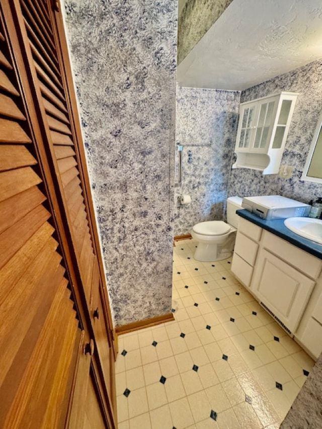 166 Gwynn St, Green Bay, WI 54301 - bathroom featuring wallpapered walls, vanity, toilet, and tile patterned flooring