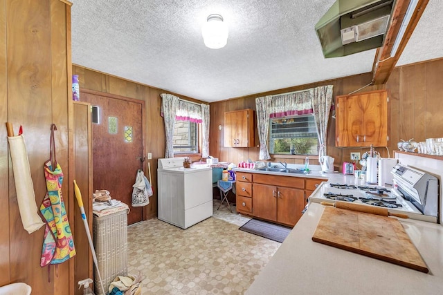 127 N 7th St, Winneconne, WI 54986 - kitchen with wooden walls, a sink, range with gas cooktop, brown cabinetry, and light countertops