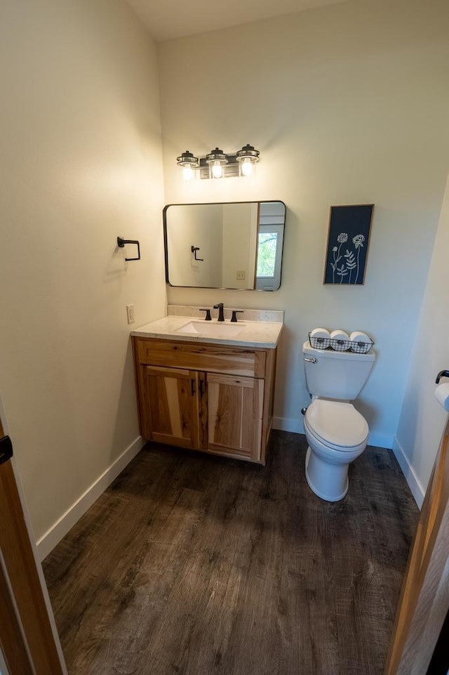 S1579 Butler Rd, Hillsboro, WI 54634 - half bath featuring vanity, toilet, wood finished floors, and baseboards