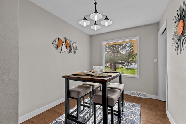 751 Warsaw St, Menasha, WI 54952 - dining space featuring a chandelier, baseboards, and wood finished floors