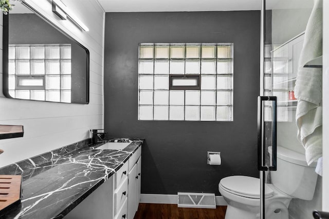 751 Warsaw St, Menasha, WI 54952 - bathroom featuring toilet, vanity, and wood finished floors