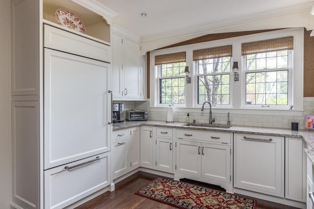 1030 Washington Ave, Oshkosh, WI 54901 - kitchen with a sink, white cabinets, backsplash, dark wood-style floors, and ornamental molding