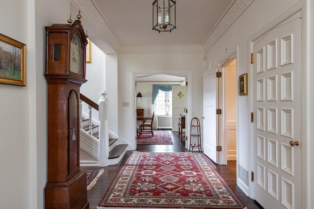 1030 Washington Ave, Oshkosh, WI 54901 - entrance foyer featuring stairway, dark wood-type flooring, radiator heating unit, and crown molding