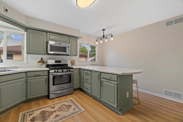 8706 W Arthur Ave, West Allis, WI 53227 - kitchen with appliances with stainless steel finishes, green cabinetry, a peninsula, and light countertops