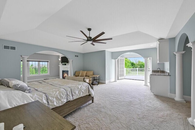 W292S5474 Fox Run Ct, Waukesha, WI 53189 - bedroom featuring access to outside, a glass covered fireplace, light carpet, vaulted ceiling, and baseboards