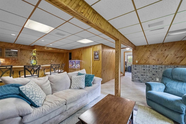 812 Clover Ln, Deforest, WI 53532 - living room featuring a drop ceiling, wooden walls, and light carpet