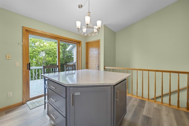812 Clover Ln, Deforest, WI 53532 - kitchen featuring gray cabinetry, a chandelier, wood finished floors, a kitchen island, and hanging light fixtures