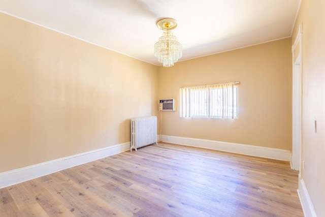 1031 S 15th St, Milwaukee, WI 53204 - empty room with radiator heating unit, a chandelier, wood finished floors, and baseboards