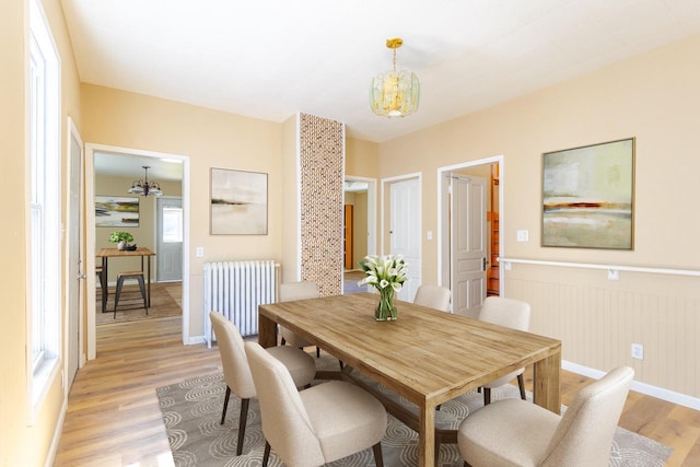 1031 S 15th St, Milwaukee, WI 53204 - dining space with radiator heating unit, a chandelier, light wood-type flooring, wainscoting, and baseboards