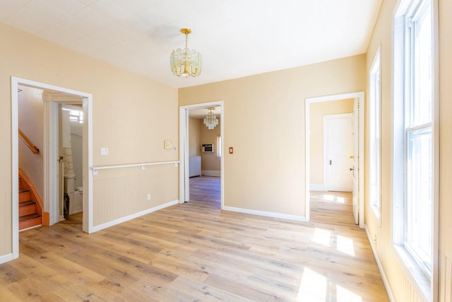 1031 S 15th St, Milwaukee, WI 53204 - spare room featuring a chandelier, light wood-style floors, stairway, and baseboards