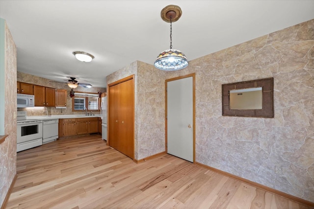 W159N4835 Graysland Dr Unit E, Menomonee Falls, WI 53051 - kitchen featuring white appliances, a sink, brown cabinets, light countertops, and light wood-style flooring